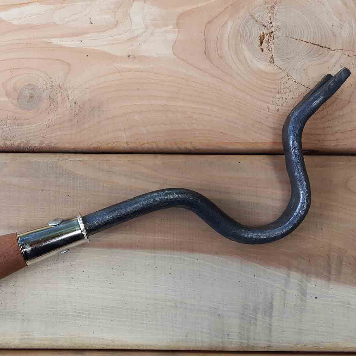 Go straight down at the base of the weed. Pull or push the wooden handle down and use the metal curve as a fulcrum for lifting out the weed.