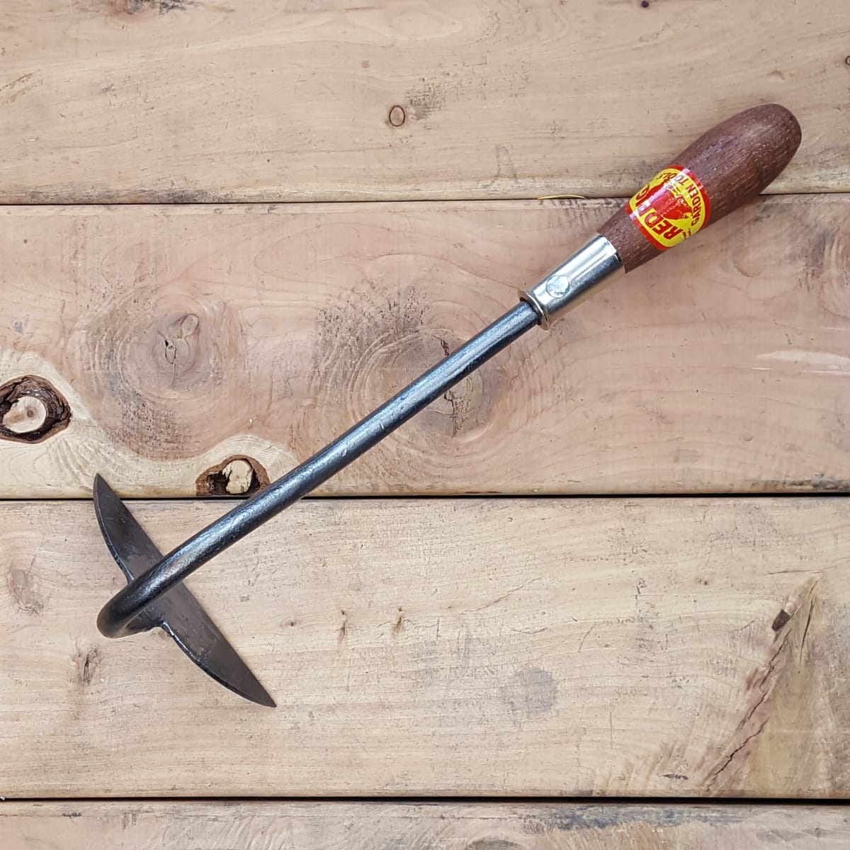 A half moon draw hoe for cutting and slicing weeds in beds with good spacing between plants.