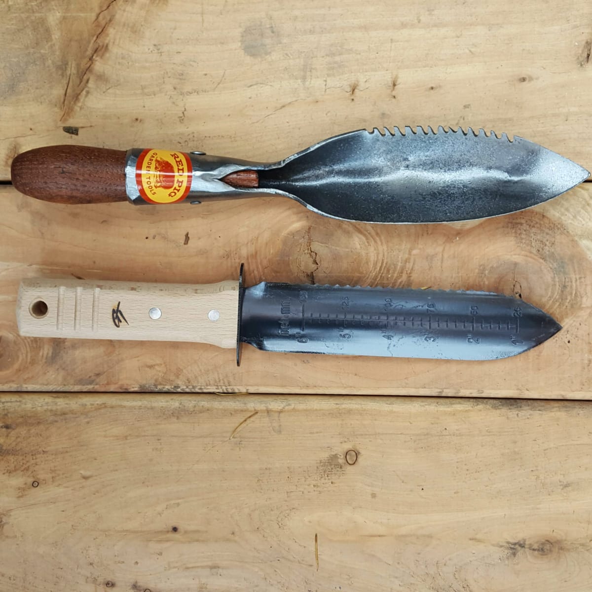 The old carbon steel version next to the Red Pig Hori Hori trowel.