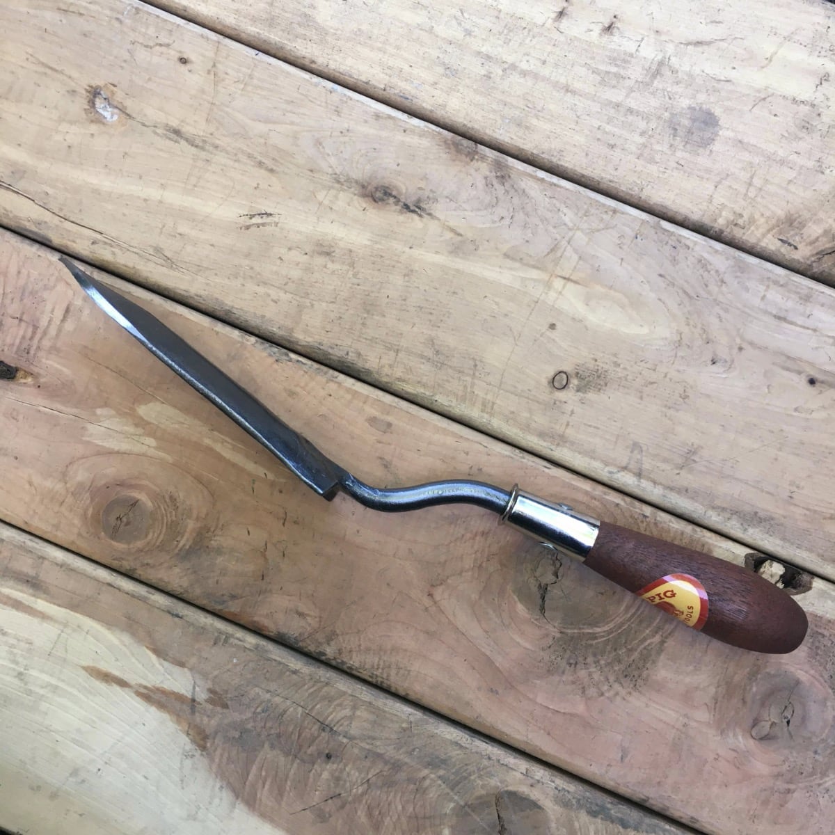 A side view of the potting trowel; the cupped side is pointed away from the handle to keep your hand out of the way.