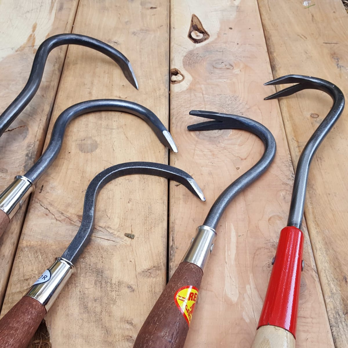 Comparison of weed yanks on the right to the single-tine cultivator or finger hoe on the left. The weed yank at the far right is on a long handle.