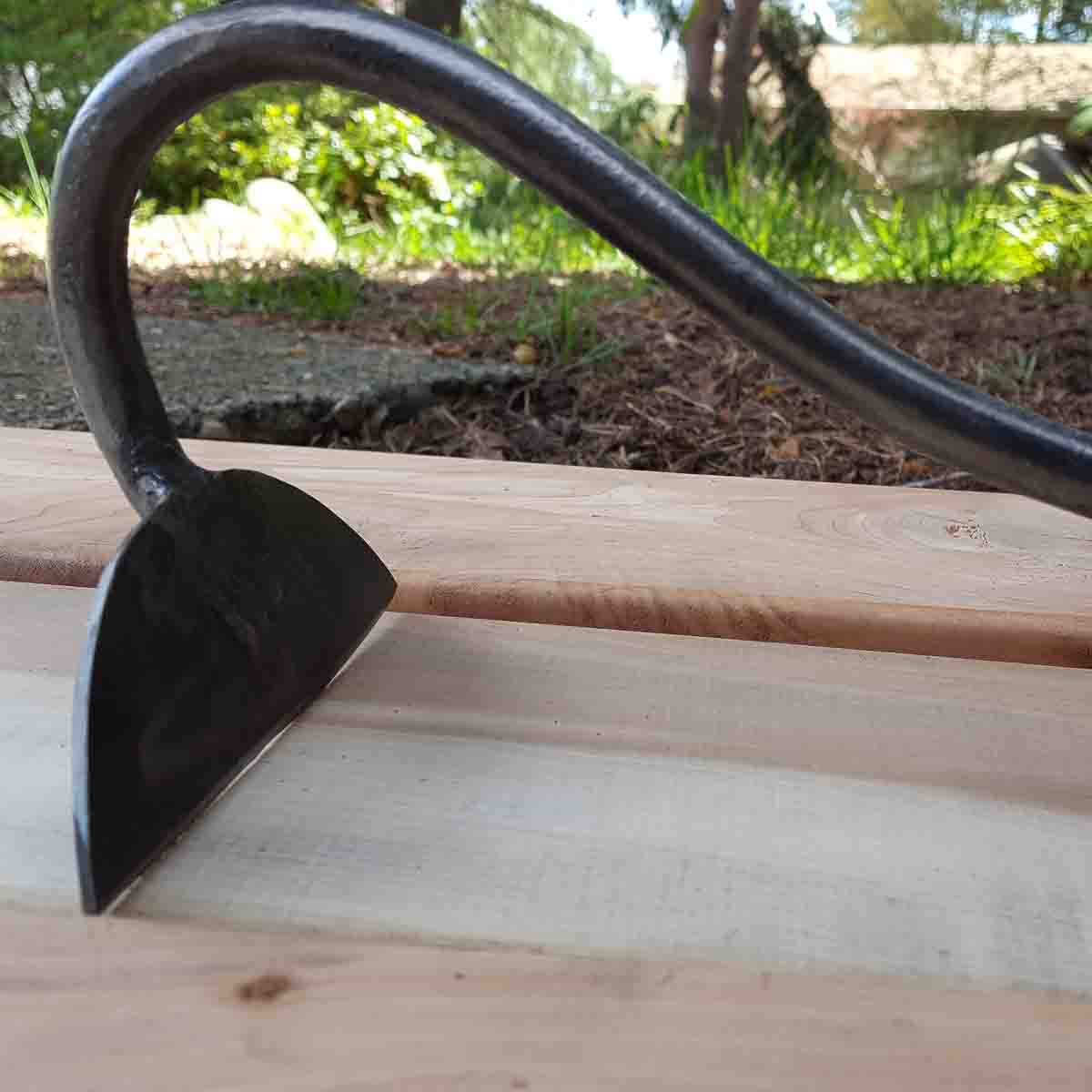 A half moon hoe is used for slicing weeds. The blade will be almost parallel at ground level and is drawn toward you. The front edge is sharpened.