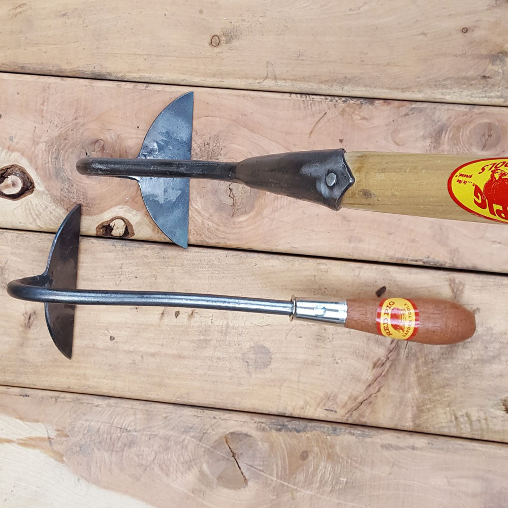 The half moon hoe is also available on a long handle for use while standing for an extra charge, seen here at top in the solid socket style. Please contact us directly for the long handle version.