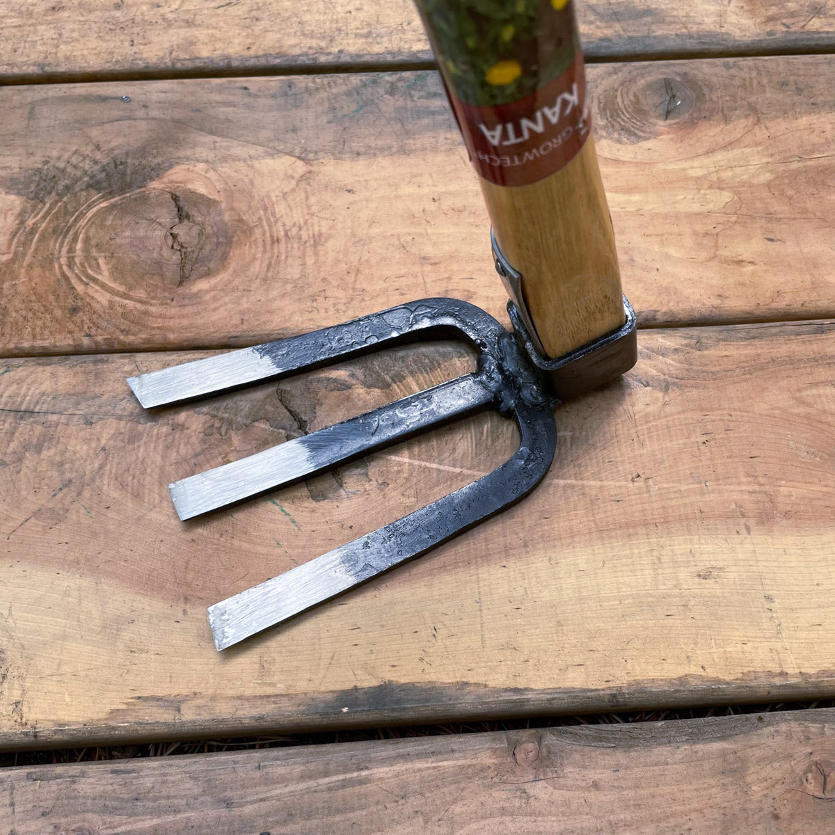 The three steel tines are flat and sharpened.