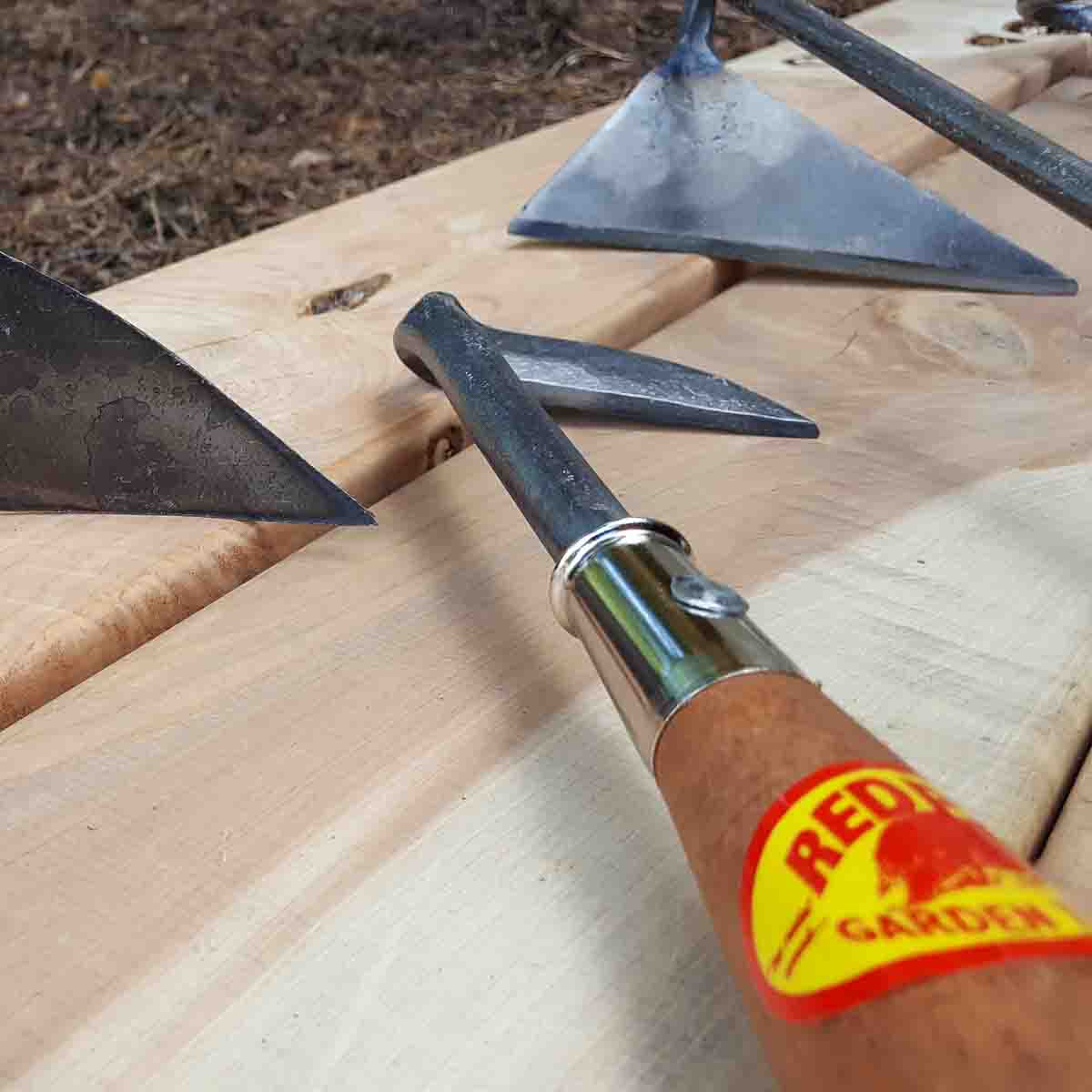 Left handed tools: hand plow, cape cod weeder, and dutch hoe.