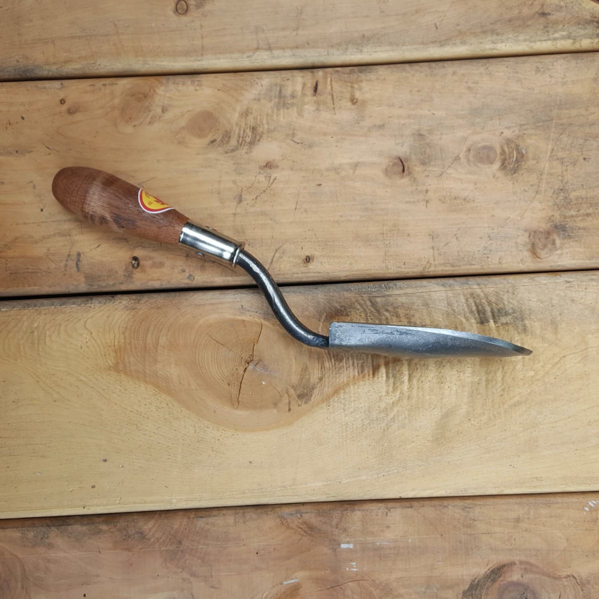 A side view of the extra small trowel shows the double bend in the shank and sharpened edge of the blade.