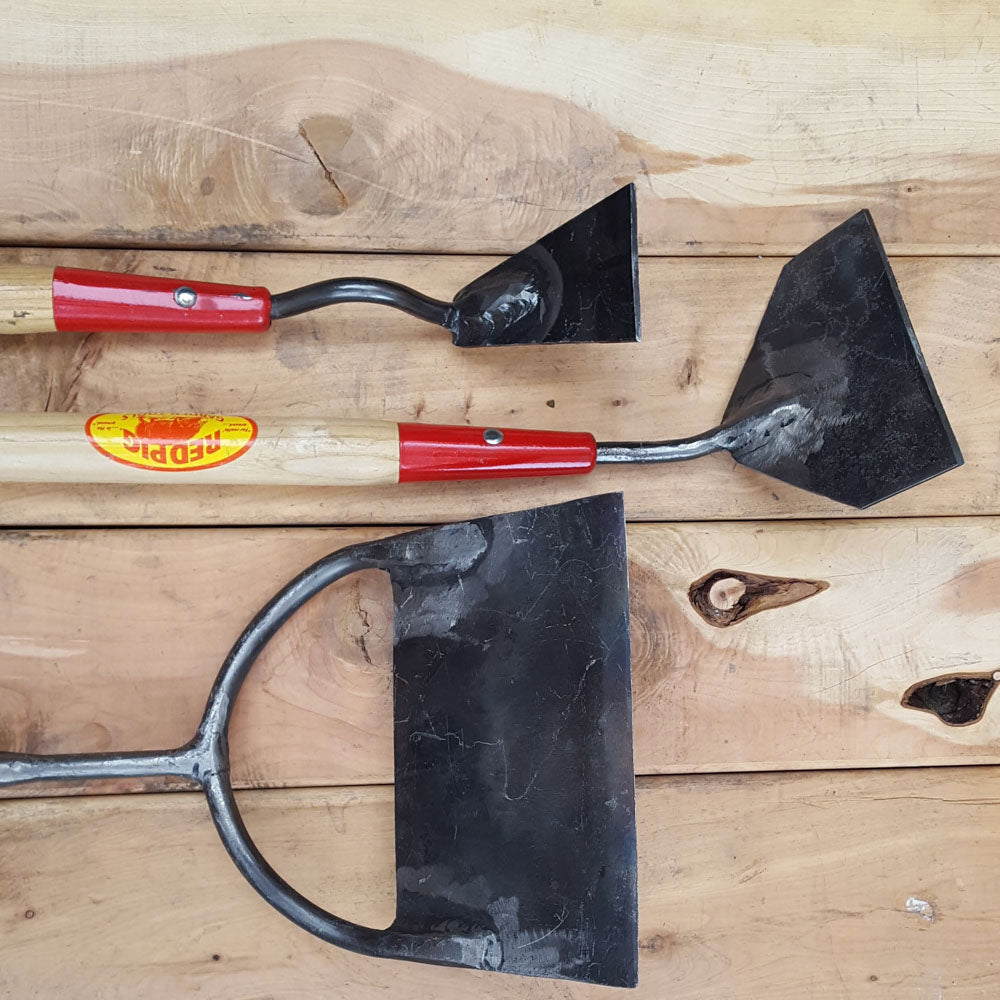 From top to bottom the narrowest to widest push hoes we offer. The narrowest hoes have one shank attached at the center, while the wider styles have two- one at either side for added strength.